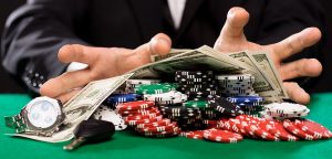 casino, gambling, people and entertainment concept - close up of poker player with chips, money and personal stuff at green casino table